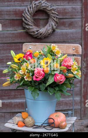bouquet con rose rosa, girasoli, fiori di giglio e fiori in secchio d'epoca Foto Stock
