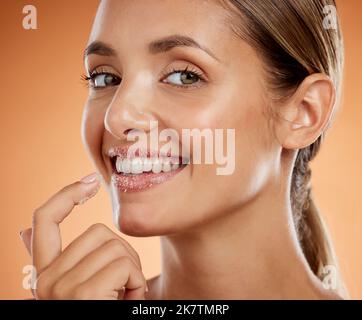 Donna bellezza, zucchero scrub labbra e cosmetici viso per la pelle per bocca, trucco e viso estetica su sfondo studio. Ritratto di modello felice Foto Stock