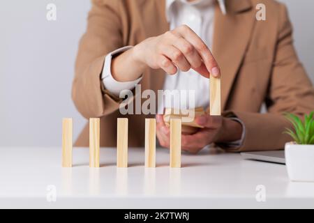 Primo piano mano donna impilato blocchi di legno sulla scrivania Foto Stock