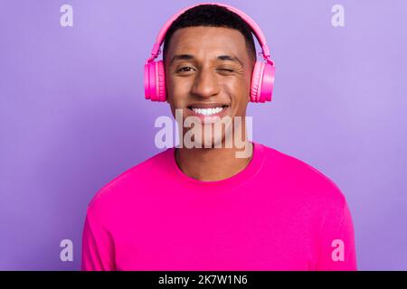 Primo piano foto del ragazzo macho giovane positivo studente Blink il suo occhio toothy beaming sorriso hollywood egocentrico isolato su sfondo di colore viola Foto Stock