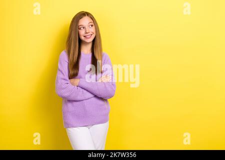 Foto di giovane adolescente attraente scolaretta mentalità guardando spazio vuoto pubblicità mentalità scelta nuovi vestiti isolati su colore giallo brillante Foto Stock