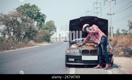 L'uomo africano chiede aiuto perché la sua auto si rompe sulla strada Foto Stock