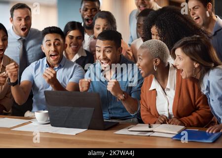 Perché volare in alto quando si può volare. un gruppo di giovani uomini d'affari che utilizzano un notebook e che si sono scioccati in un ufficio moderno. Foto Stock