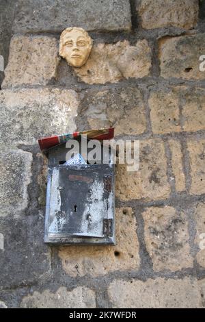 Piccola cassetta postale attaccata ad un muro di pietra su una proprietà in Italia Foto Stock