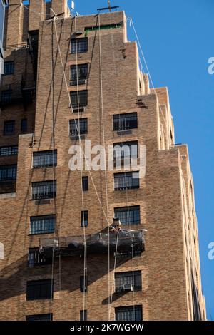 Operai edili sopra una strada urbana a New York City in una piattaforma sospesa, Midtown Manhattan, USA 2022 Foto Stock