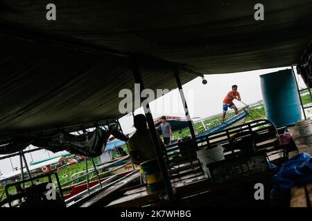 Binangonan, Filippine. 19th Ott 2022. Fisherman naviga la sua barca a Laguna Lake. Il lago Laguna di 94.900 ettari nelle Filippine ospita specie come la carpa di mare, la carpa di acqua dolce, la carpa, il pesce latte, la tilapia, e gamberi, che possono essere catturati nelle aree aperte del lago. I pescatori di Binangonan Fishport sono pagati 100 pesos filippini (1,69 USD) per tonnellata di pesce catturato. Una barca normale può trasportare circa 5 tonnellate di pesce. Credit: SOPA Images Limited/Alamy Live News Foto Stock