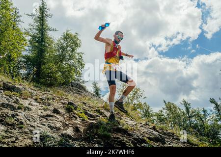 Bannoe, Russia - 31 luglio 2022: Corridore maschio correre ripida discesa di montagna in MCK Wild Trail Foto Stock