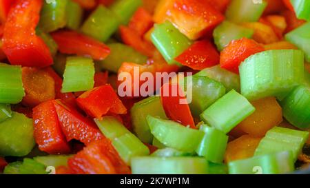 Verdure crude appena tagliate su un asse di legno. Sedano e paprika. Preparato per cucinare Foto Stock