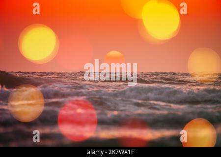 Sole splendente sull'orizzonte al tramonto o all'alba. Sera mare. Le onde dell'oceano nei colori caldi tramonti sunrise Sky lights. Ondulazione del condimento. Luce parassita, torcia Foto Stock