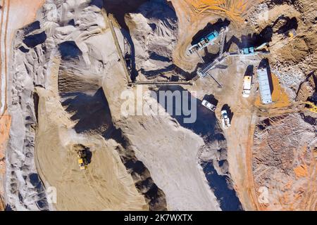 Una panoramica dell'attrezzatura di frantumazione della pietra sul nastro trasportatore meccanico che polverizza la pietra per la produzione di ghiaia in vista panoramica Foto Stock