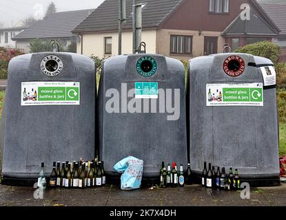 Bottiglie e bicchieri banchi tre contenitori pieni e bottiglie di vino molti con tappi disposti all'esterno dei contenitori di raccolta Foto Stock