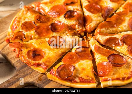 Pizza pepperoni fatta in casa a fette con pomodoro e salsa di basilico Foto Stock