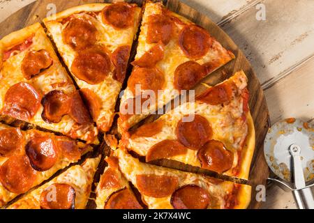 Pizza pepperoni fatta in casa a fette con pomodoro e salsa di basilico Foto Stock