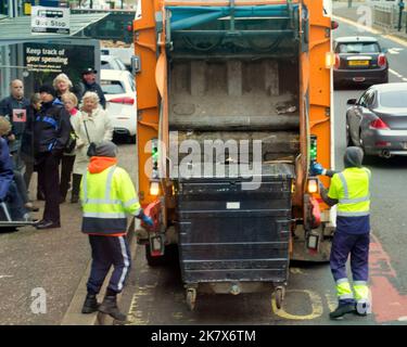 carretto per la polvere e binmen che caricano davanti alla fermata dell'autobus Foto Stock