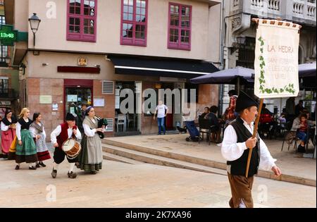 Un gruppo di danza popolare in costumi tradizionali camminando in processione alla musica bagpipe durante le parti del disarmo 15 ottobre 2022 Spagna Foto Stock