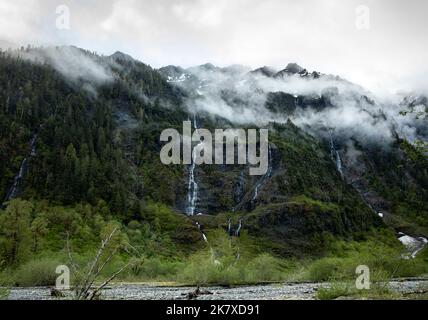 WA22384-00...WASHINGTON - Nubi che si riversano sulle montagne sopra le cascate di Enchanted Valley; parte del Parco Nazionale Olimpico. Foto Stock