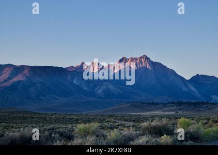 Luce dell'alba che illumina un'aspra cima di montagna nella Sierra Nevada orientale Foto Stock