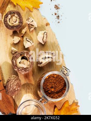 Pezzi di funghi secchi con polvere di chaga su un podio di legno Foto Stock