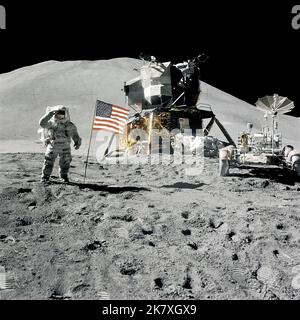 Gli astronauti dell'Apollo 15 Jim Iwrin e David Scott disposero sulla luna il primo veicolo Lunar Roving. Durante il loro soggiorno di 67 ore, hanno utilizzato la rover per fare tre viaggi separati oltre il sito di atterraggio di Hadley-Appennine. Qui, Irwin saluta la bandiera americana mentre si trova accanto al modulo Lunar e rover. Foto Stock