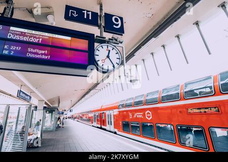 25 luglio 2022, Osnabruck, Germania: Una piattaforma ferroviaria con un moderno treno ad alta velocità in partenza secondo l'orario di partenza per Dusseldorf Foto Stock