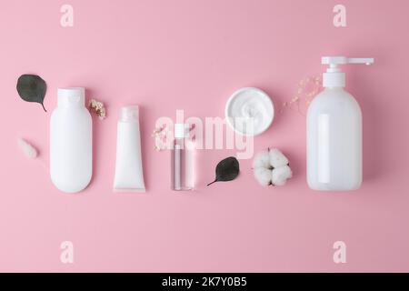 Composizione cosmetica con prodotti per la cura della pelle su sfondo rosa. Giacitura piatta, spazio di copia Foto Stock