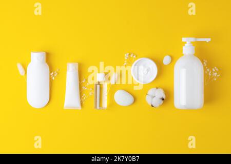 Composizione cosmetica con prodotti per la cura della pelle su sfondo giallo. Giacitura piatta, spazio di copia Foto Stock