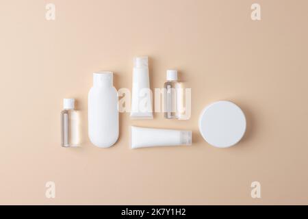 Composizione cosmetica con prodotti cosmetici per la cura della pelle e su sfondo beige pastello. Giacitura piatta, spazio di copia Foto Stock