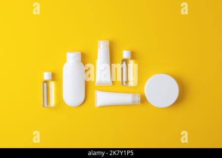 Composizione cosmetica con prodotti cosmetici per la cura della pelle e su sfondo giallo. Giacitura piatta, spazio di copia Foto Stock