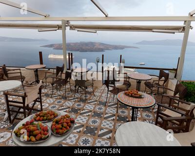 Ristorante a Fira con vista sulla Caldera, capitale dell'isola greca delle Cicladi di Santorini nel Mar Egeo. Su alcuni tavoli sono disposte delle pere Prickly. Foto Stock