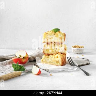 La torta di mele tagliata a fette di pasta frolla con crema pasticcera e noci si trova su un mucchio di fondo chiaro. Ricette per torte di mele. Giorno del Ringraziamento. Foto Stock