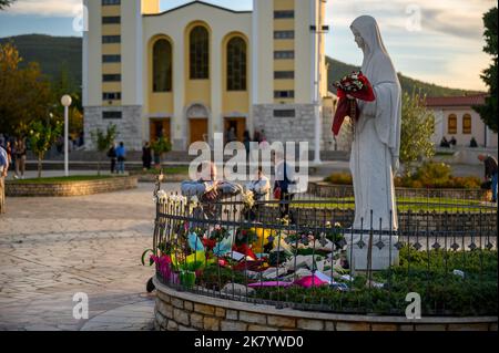 La gente prega intorno alla statua della Regina della Pace vicino alla Chiesa di San Giacomo a Medjugorje, Bosnia-Erzegovina. Foto Stock