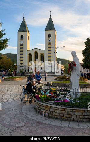 La gente prega intorno alla statua della Regina della Pace vicino alla Chiesa di San Giacomo a Medjugorje, Bosnia-Erzegovina. Foto Stock