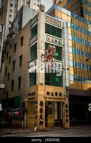 Il Pawnshop Tak Wing, un tradizionale negozio cinese di pegni in una bottega 'Tong lau' accanto ad un alto e moderno edificio di uffici, il Central, Isola di Hong Kong Foto Stock