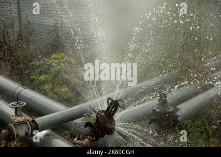 Incidente della tubazione. L'acqua bollente versa dal tubo. Emergenza locale caldaia. Situazione industriale. Foto Stock