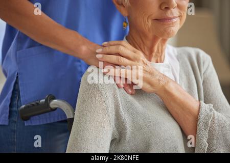 Mano, infermiera e donna anziana paziente con disabilità che tiene le mani homecare lavoratore per empatia, gentilezza e assistenza sanitaria. Operatore sanitario, volontario Foto Stock
