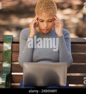 Donna nera, laptop e stress per gli esami, ansioso e mal di testa per gli studi, all'aperto e sul banco. Studentessa, giovane donna e con digitale Foto Stock