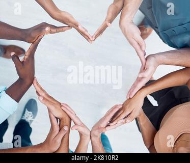 Le mani del lavoro di squadra, il cuore e la collaborazione di diversità, il sostegno del personale di affari o la cura della comunità, la motivazione e la fiducia. Sopra la squadra di gruppo che costruisce per Foto Stock