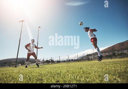 Uomo, calcio e squadra in allenamento sportivo, esercizio e allenamento per il fitness sul campo all'aperto. Uomini sportivi che giocano nel calcio con la testa Foto Stock