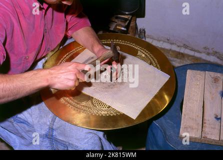 Siria: Artigiano di brassware nel grande bazar antico, Aleppo (1997). Il Grande Bazar di Aleppo (in arabo, suq o suq) fu ricostruito prima dai Mamelucchi egiziani che scacciarono i Mongoli, e poi, dopo il 1516, dai Turchi che incorporarono Aleppo nell'Impero Ottomano. Durante la guerra civile siriana, iniziata nel 2011, i suq storici di Aleppo subirono gravi danni. Aleppo, la seconda città della Siria è forse il più lungo insediamento continuamente abitato del mondo. Il suo nome arabo, Halab, è menzionato nei testi semitici del terzo millennio a.C.. Foto Stock