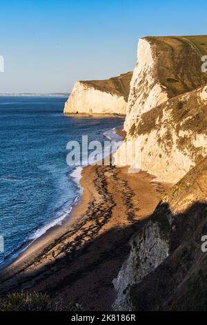 Vista su Man o'War Beach nel Dorset guardando verso ovest all'alba. Foto Stock