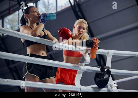 Giovani atleti, pugili professionisti, kickboxer hanno un riposo dopo un duro allenamento in palestra sportiva. Concetto di sport, allenamento, attivo e sano Foto Stock