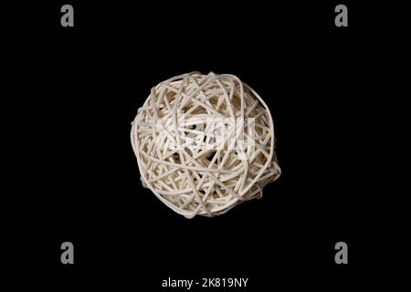 una palla tessuta da una vite di bambù di legno su uno sfondo nero Foto Stock