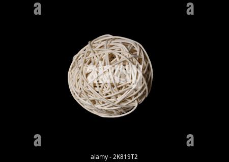 una palla tessuta da una vite di bambù di legno su uno sfondo nero Foto Stock