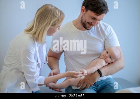 Medico neonatale esperto che esamina un neonato Foto Stock