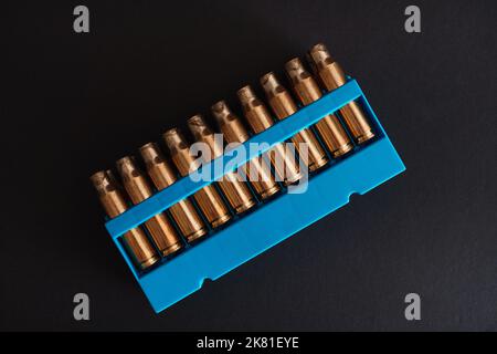 Contenitori a pallottola vuoti in oro ambrato con supporto blu Foto Stock