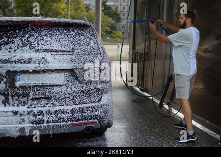 Ama la sua auto. Uomo lavaggio auto. Foto Stock