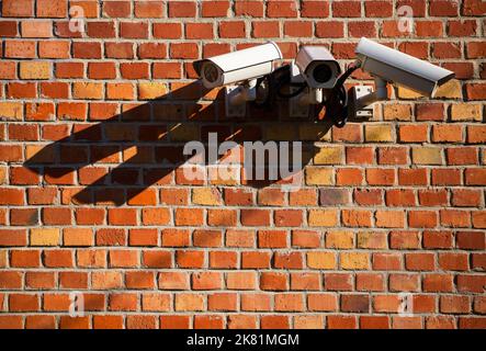 Gruppo di telecamere di sicurezza sulla parete in mattoni rossi Foto Stock