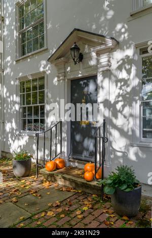 Esposizione autunnale di zucche e foglie cadenti sul gradino della porta di una casa georgiana nella graziosa cittadina di Tenterden nel Kent UK, pronta per Halloween! Foto Stock