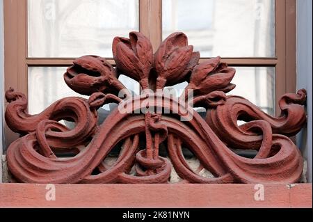 Ornamento floreale curvo sulla facciata del vecchio edificio Foto Stock