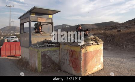 NABLUS, CISGIORDANIA - 19 OTTOBRE: I soldati israeliani stanno in guardia dietro blocchi di cemento nel checkpoint militare di Beit Furik il 19 ottobre 2022 situato all'entrata orientale di Nablus, Cisgiordania. Le forze israeliane hanno imposto un continuo blocco sulla zona intorno a Nablus, tra le tensioni più forti in Cisgiordania che limitano il movimento di circa 420.000 palestinesi. Credit: Eddie Gerald/Alamy Live News Foto Stock